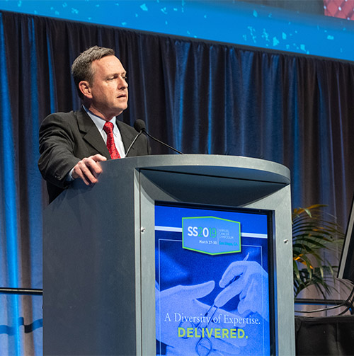 Dr. Bartlett at the podium at the conference